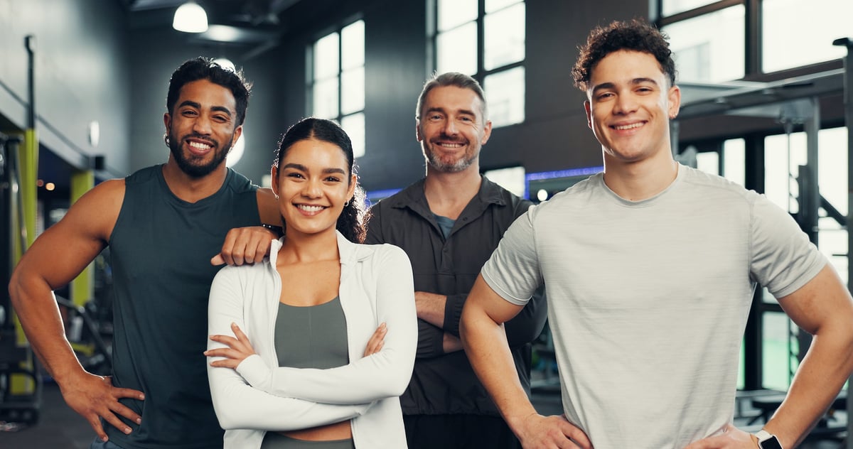 Fitness, friends and portrait of people in gym with smile for exercise, training and workout. Sports center, personal trainer and happy men and woman with confidence for wellness, health and support